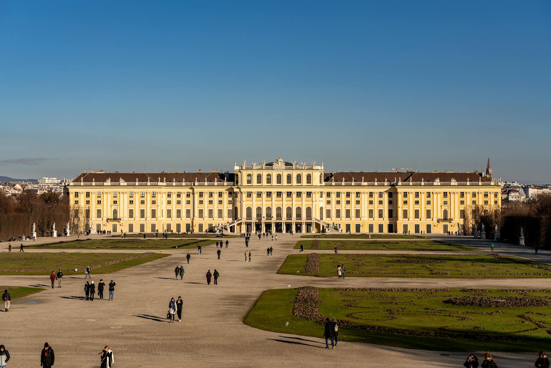 Schönbrunn Palace in Vienna with visitors strolling through the majestic gardens