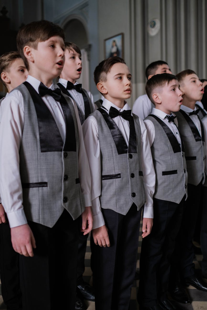 Boys choir singing in formal performance with sheet music