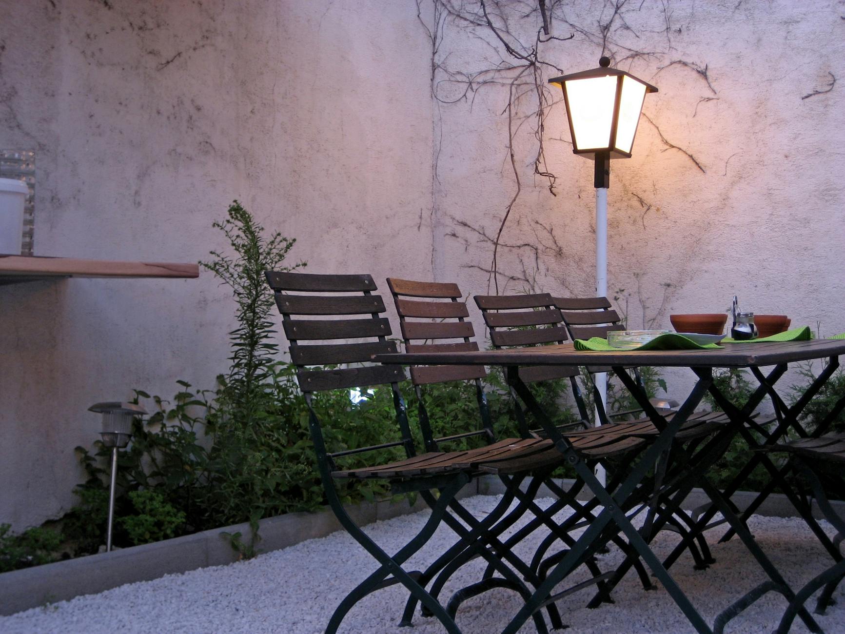 Charming restaurant garden in Vienna with wooden chairs and climbing vines — outdoor dining in the city