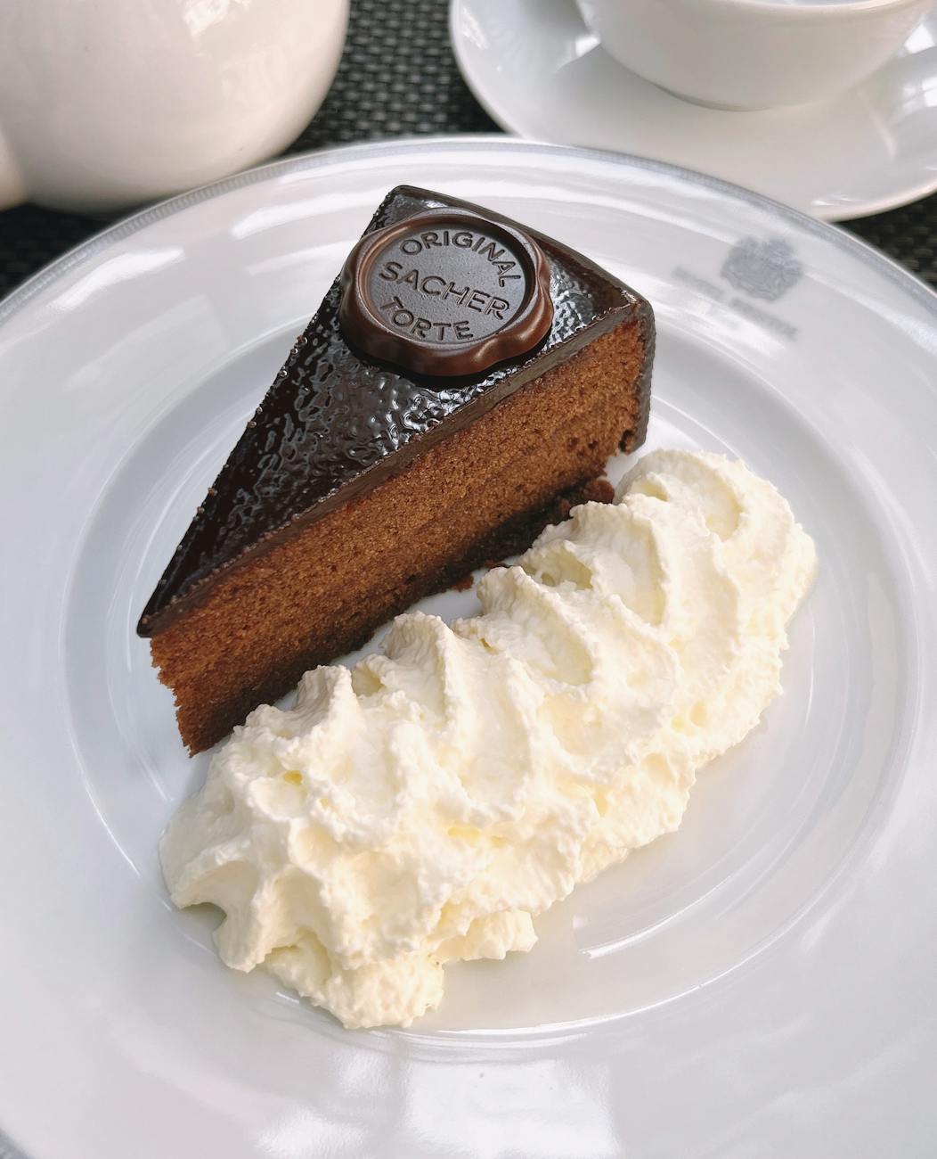 A slice of the original Sachertorte with whipped cream — Vienna's most famous dessert