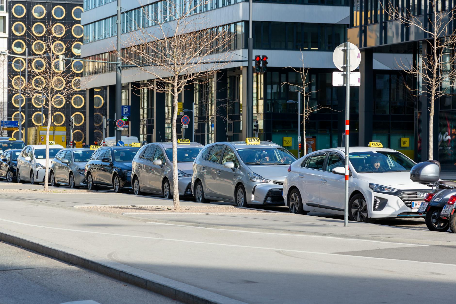 Lineup of taxis on Vienna urban street with modern buildings
