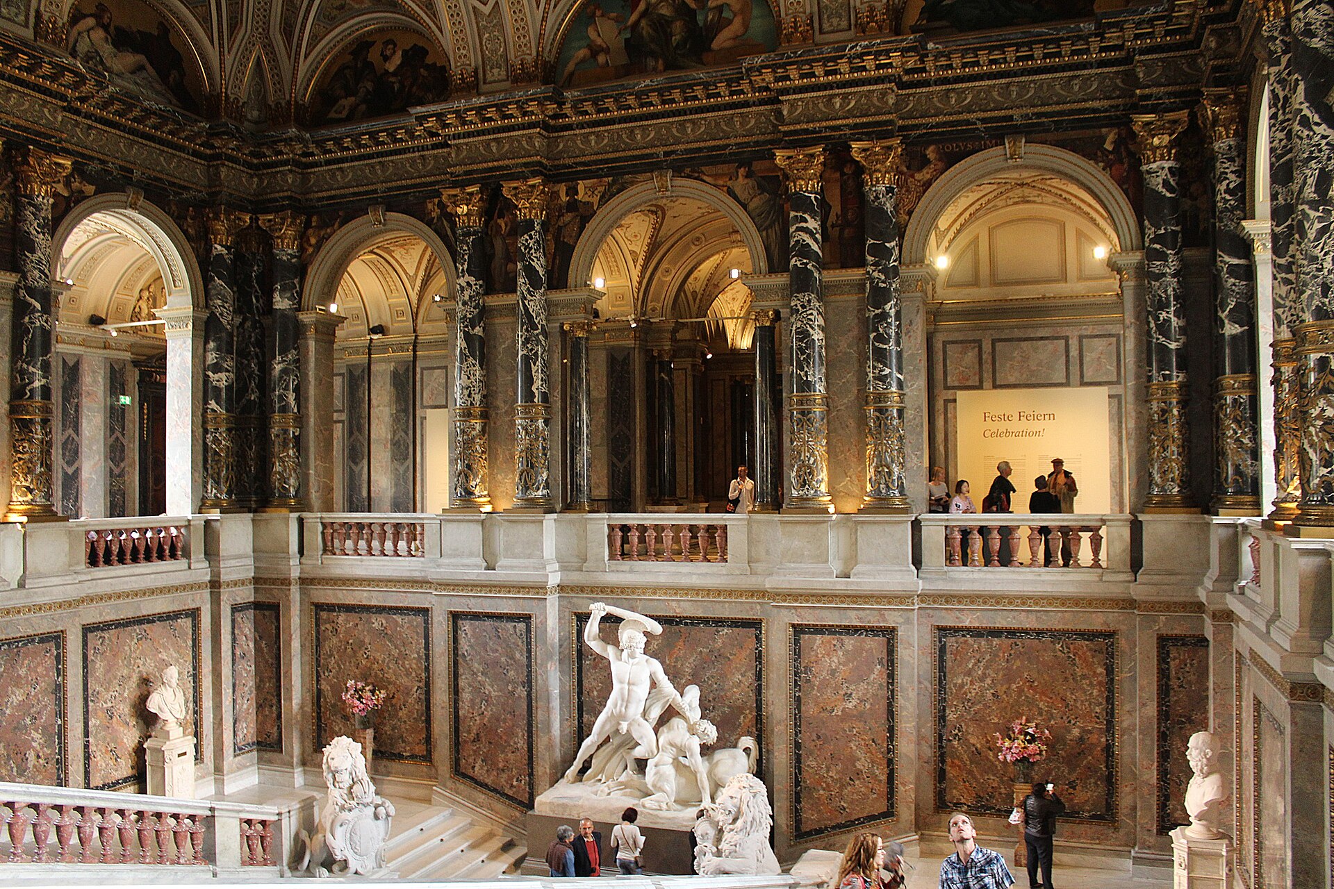 The grand marble staircase hall of the Kunsthistorisches Museum in Vienna with visitors on the upper balustrade