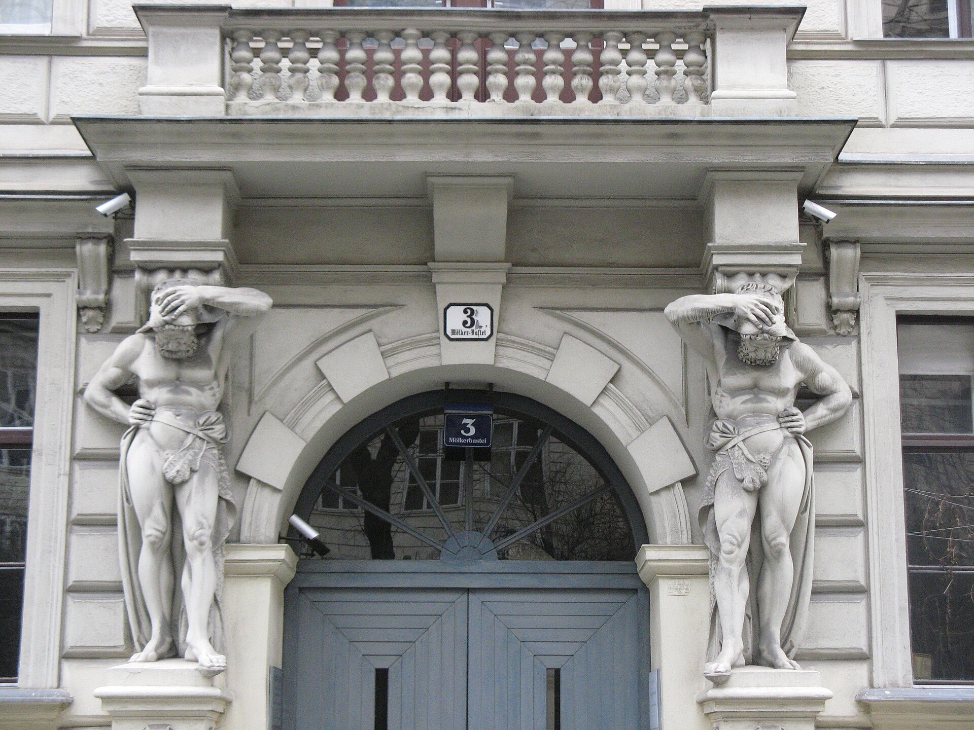 An ornate Viennese doorway at Molker Bastei 3, flanked by two carved stone atlantes bearing the arch on their shoulders