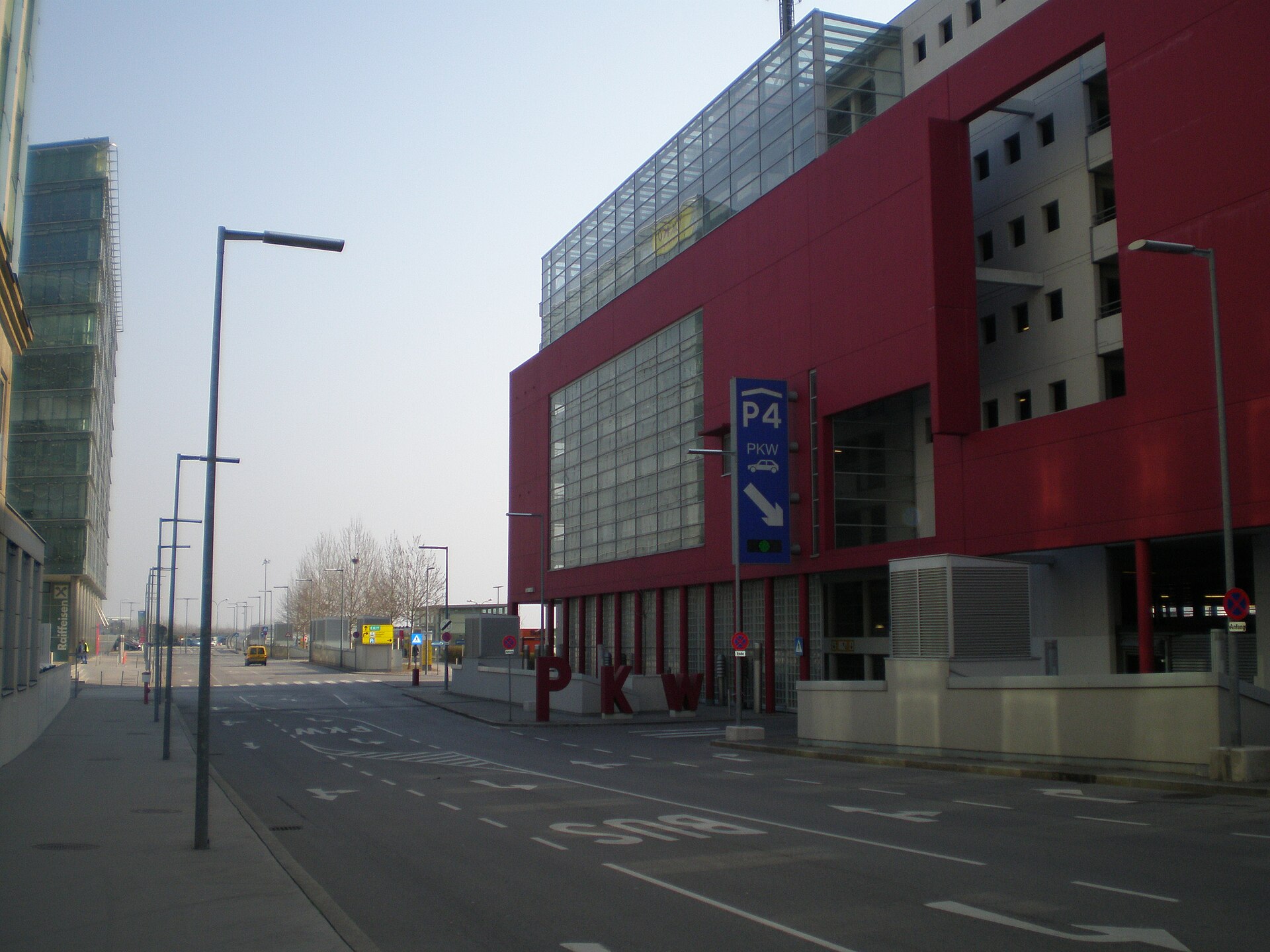 The red facade of Car Park 4 at Vienna Airport with a blue P4 sign directing cars down the ramp